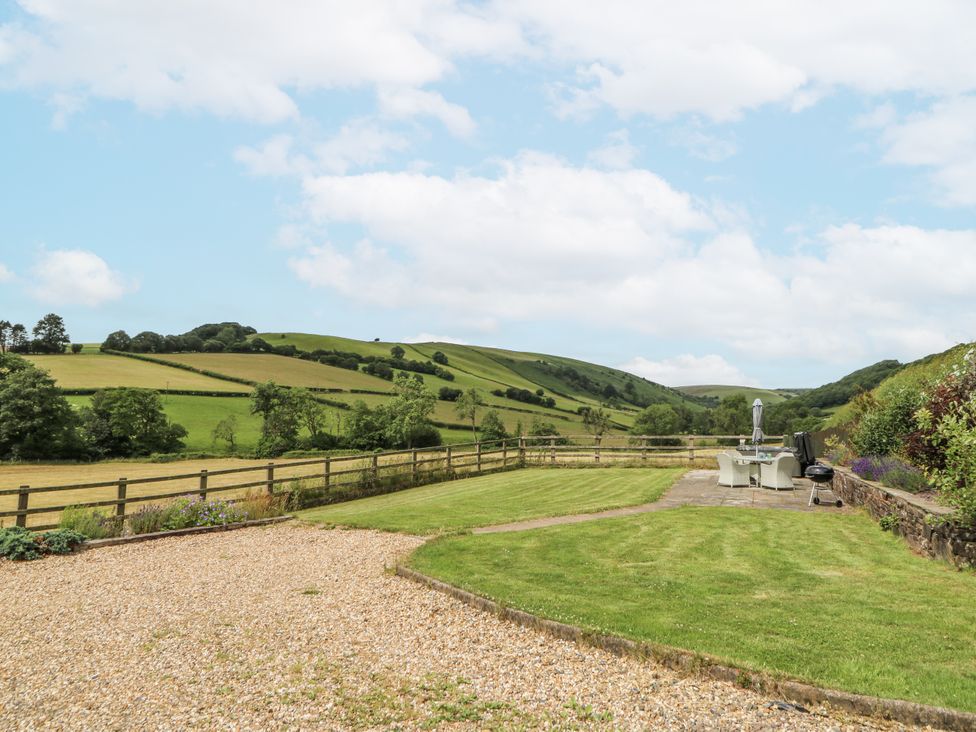 An outdoor area with garden furniture and a mountain view at Waun Yscir near Merthyr Cynog