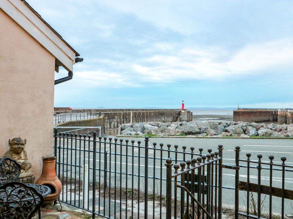An outdoor view of the shore with a lighthouse at Sammy Hakes Cottage