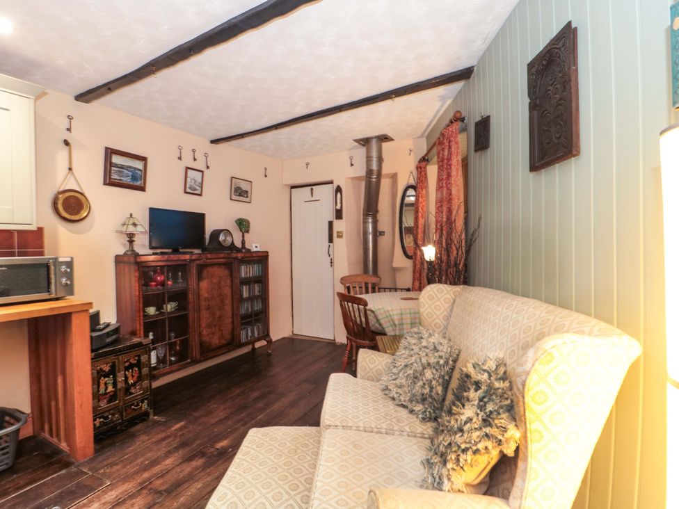 A living room with a sofa and dining table at Sammy Hakes Cottage