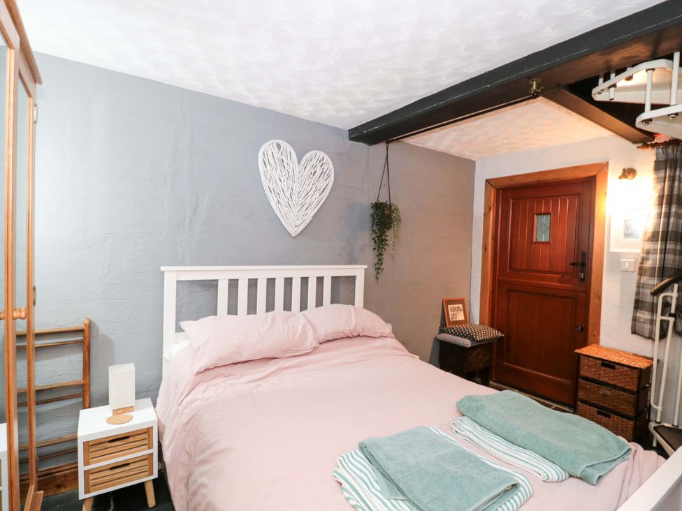 A bedroom with a bed and nightstand at Sammy Hakes Cottage