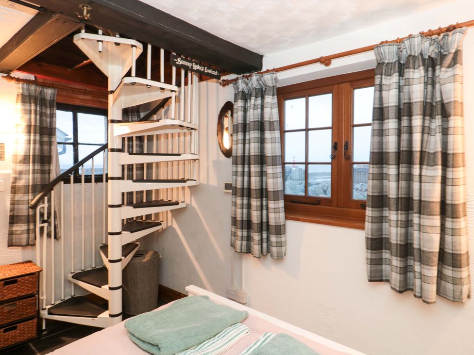 A bedroom with a spiral staircase and window at Sammy Hakes Lookout