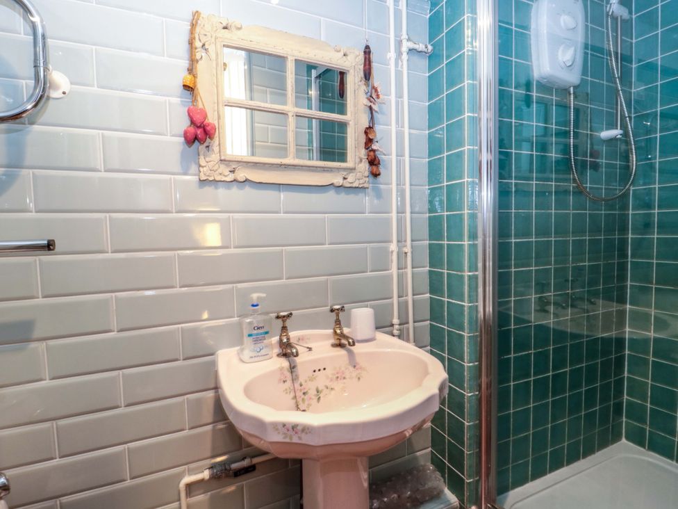 A bathroom with a sink and shower at Sammy Hakes Cottage