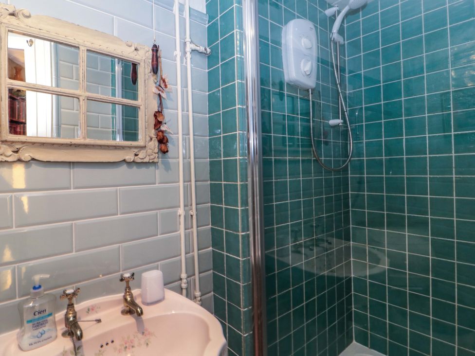 A bathroom with a shower and sink at Sammy Hakes Cottage