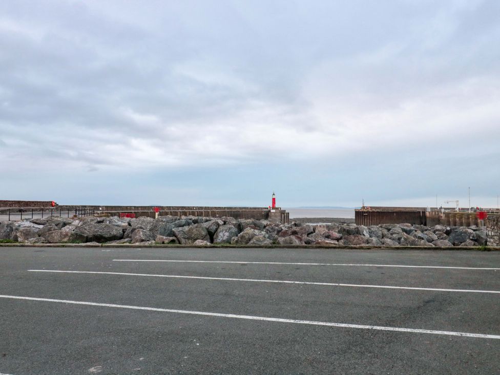 A view of a pier and lighthouse from a road at Sammy Hakes Cottage