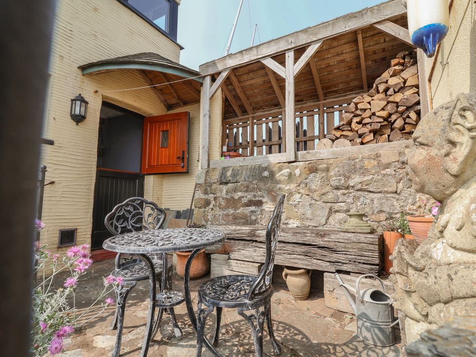 An outdoor seating area with a table and chairs at Sammy Hakes Cottage in Watchet