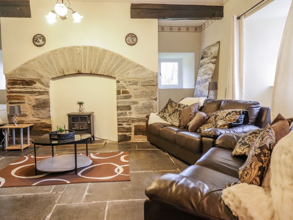 A living room with a sofa and fireplace at Cynfal Fawr Near Blaenau Ffestiniog