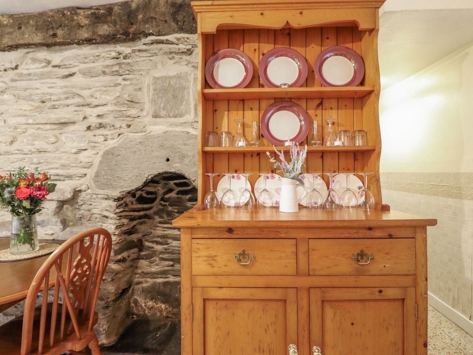 A dresser with plates and glasses in a dining room at Cynfal Fawr Near Blaenau Ffestiniog