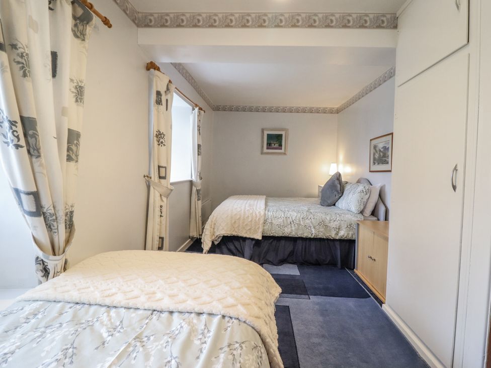 A bedroom with two beds and curtains at Cynfal Fawr near Blaenau Ffestiniog