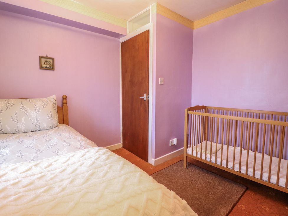 A bedroom with a bed and a crib at Cynfal Fawr Near Blaenau Ffestiniog
