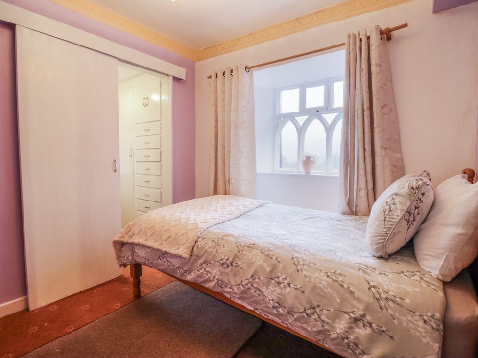 A bedroom with a bed and wardrobe at Cynfal Fawr Near Blaenau Ffestiniog