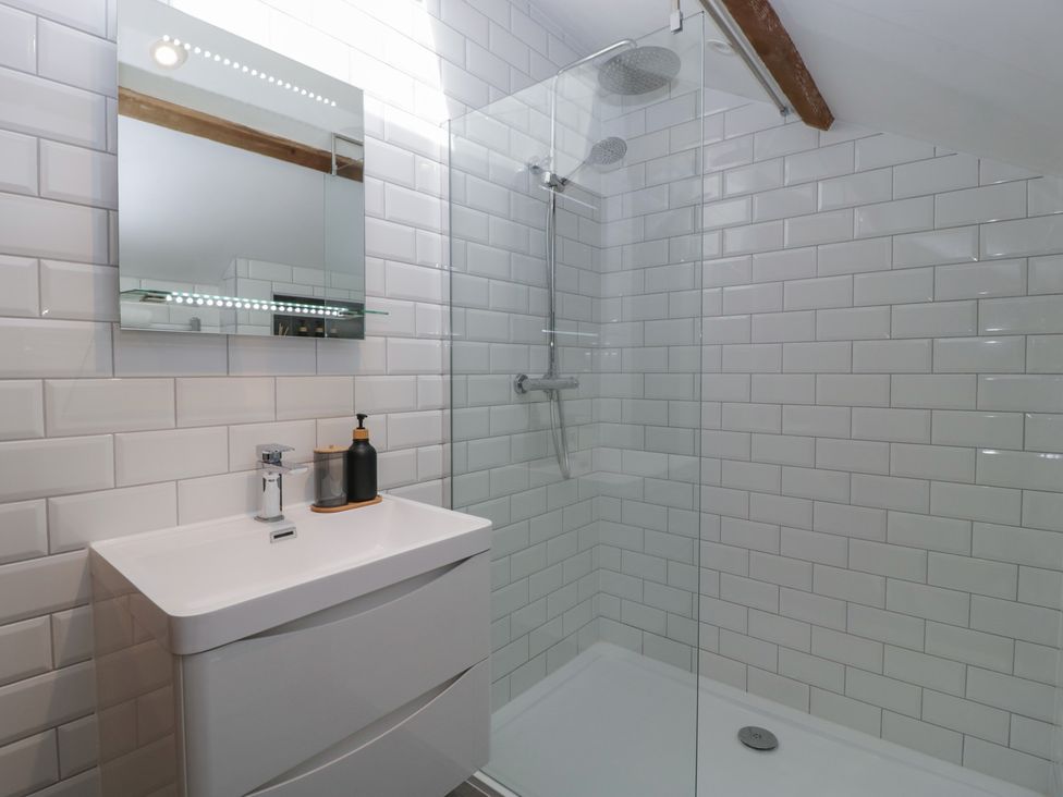 A bathroom with a sink cabinet mirror and walk in shower at Graig Cottage in Cwmcarn