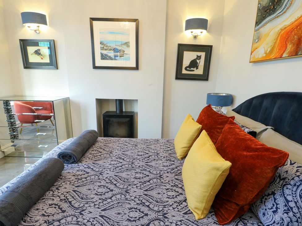 A bedroom with a bed and artworks on the wall at Bronallt Cemaes Bay