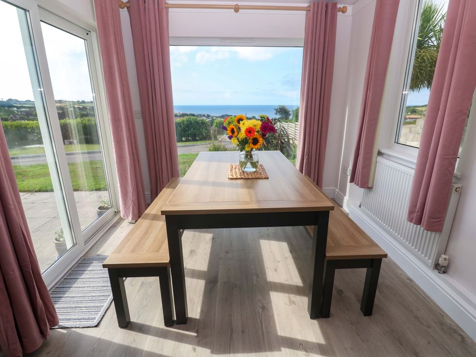 A dining room with a table and flowers at St Marys in Penzance