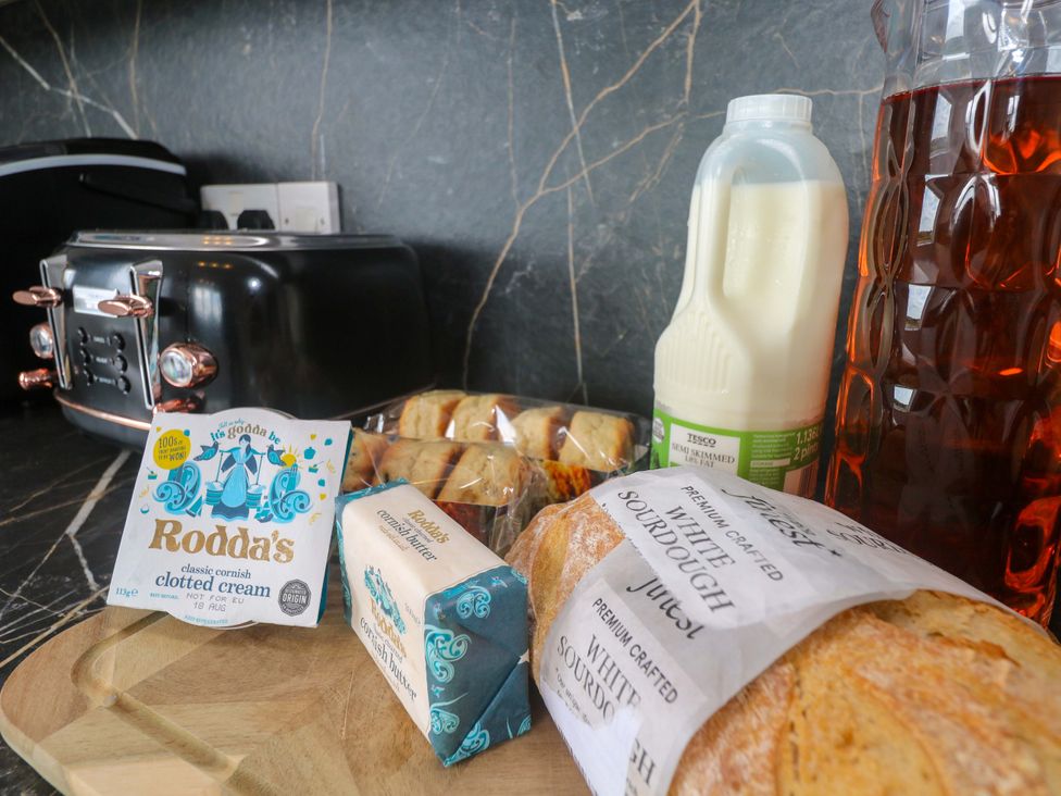 A kitchen counter with a toaster, clotted cream, butter, scones, milk, and iced tea at St Marys in Penzance