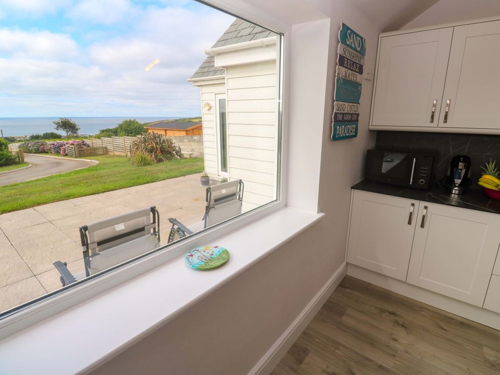 A kitchen with a window showing a sea view and kitchen appliances at St Marys in Penzance