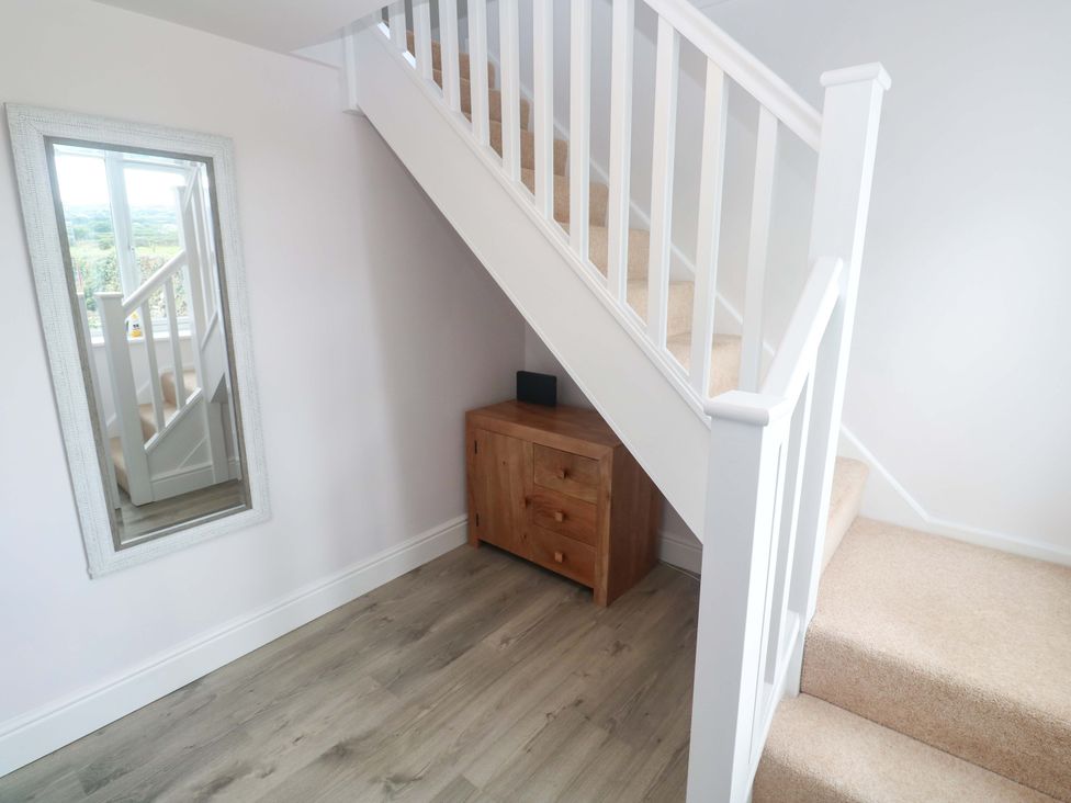 A hallway with a staircase and a console table at St Marys in Penzance