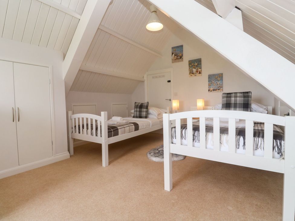 A bedroom with two beds and a wardrobe at St Marys in Germoe