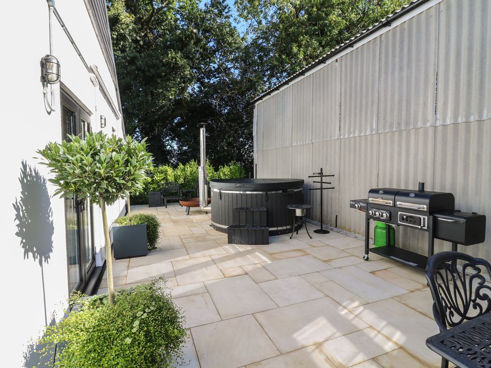 An outdoor area with a spa and grill at The Old Workshop in Wormshill near Harrietsham