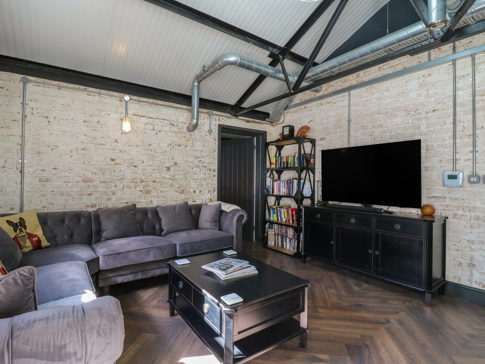A living room with a sofa and television at The Old Workshop in Wormshill near Harrietsham