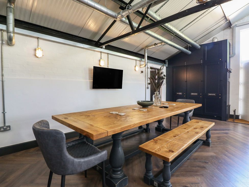A dining room with a wooden table and chairs at The Old Workshop in Wormshill near Harrietsham