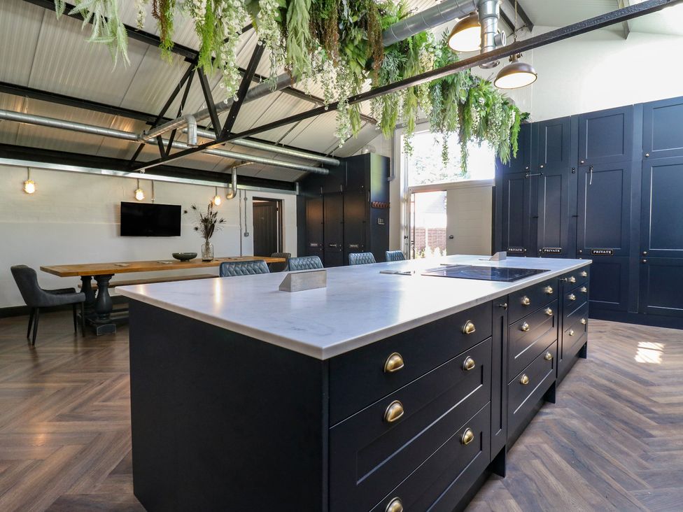 A kitchen with an island and table at The Old Workshop in Wormshill near Harrietsham