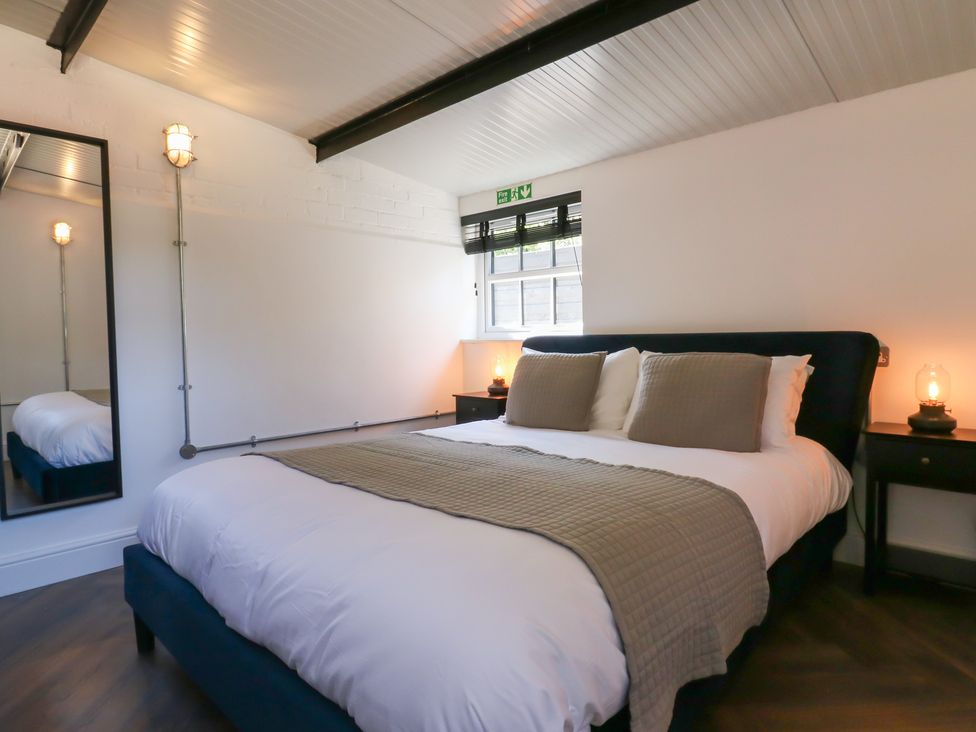 A bedroom with a bed and lamps at The Old Workshop in Wormshill near Harrietsham