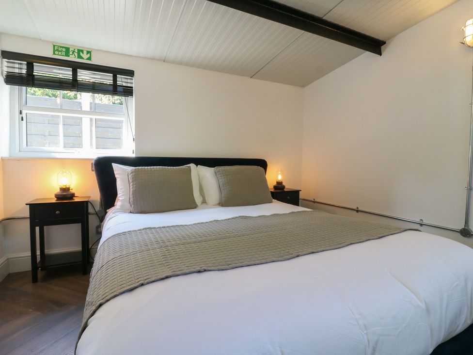 A bedroom with a bed and bedside table at The Old Workshop Wormshill near Harrietsham