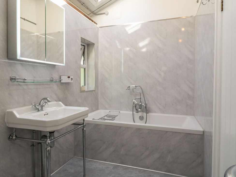 A bathroom with a bathtub and sink at The Old Workshop Wormshill near Harrietsham