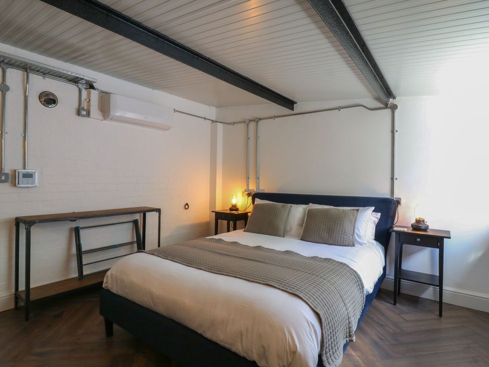 A bedroom with a bed and side tables at The Old Workshop in Wormshill near Harrietsham
