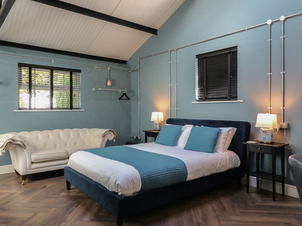 A bedroom with a bed, sofa and lamps at The Old Workshop in Wormshill near Harrietsham
