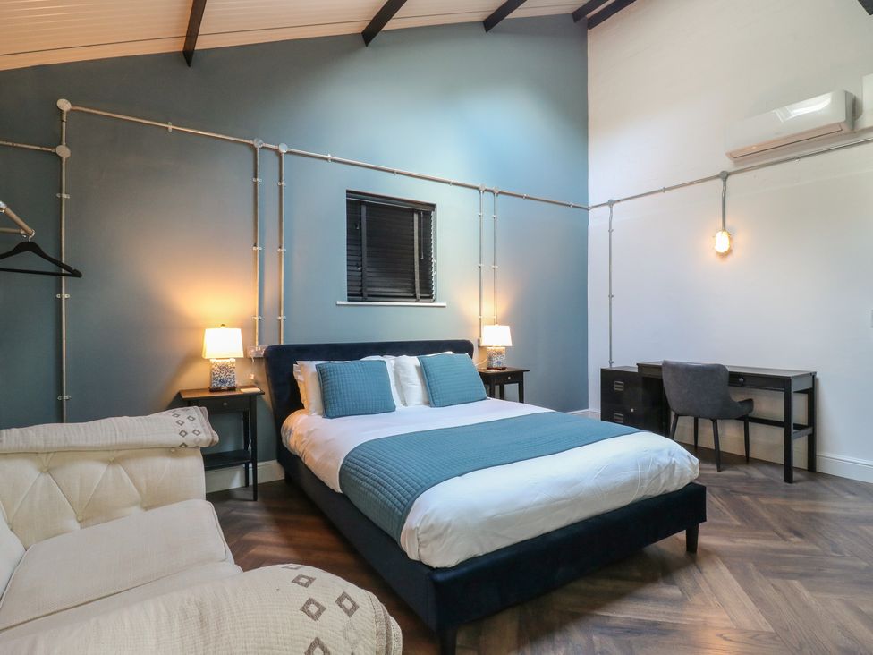 A bedroom with a bed and desk at The Old Workshop in Wormshill near Harrietsham