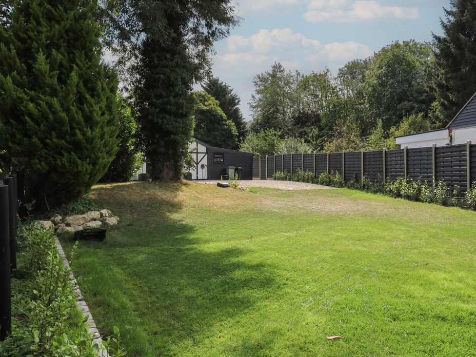 A garden with grass and trees at The Old Workshop in Wormshill near Harrietsham