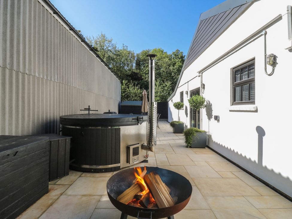 An outdoor area with a hot tub and fire pit at The Old Workshop in Wormshill near Harrietsham