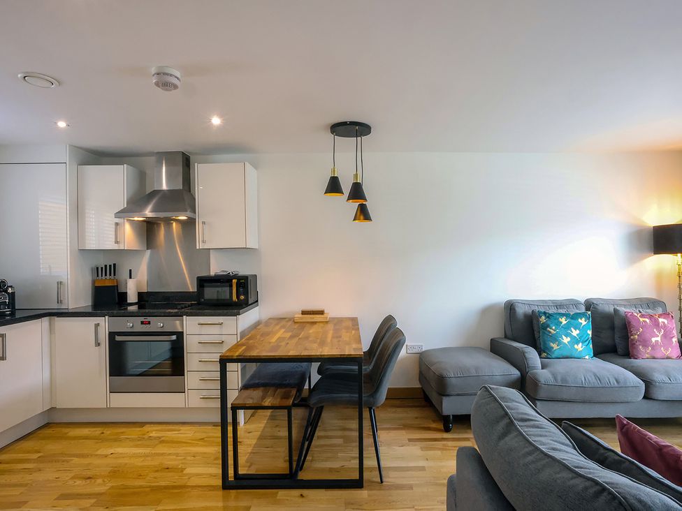 A kitchen with a dining table and sofa at Whitstable Bay Getaway in Whitstable