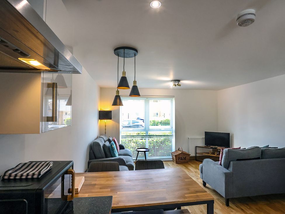 A living room with a sofa and television at Whitstable Bay Getaway in Whitstable