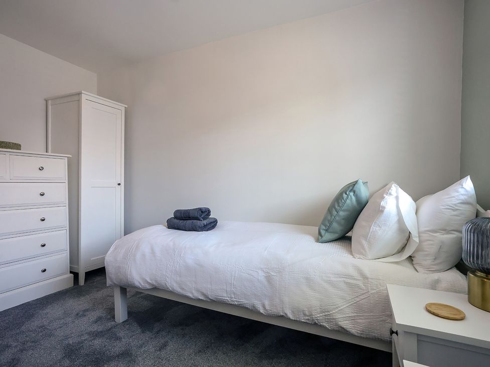 A bedroom with a bed and dresser at Whitstable Bay Getaway in Whitstable