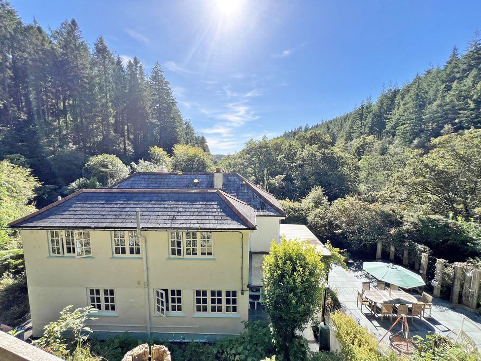 A house with a patio and garden area at Lost In The Woods Lodge near Bodmin