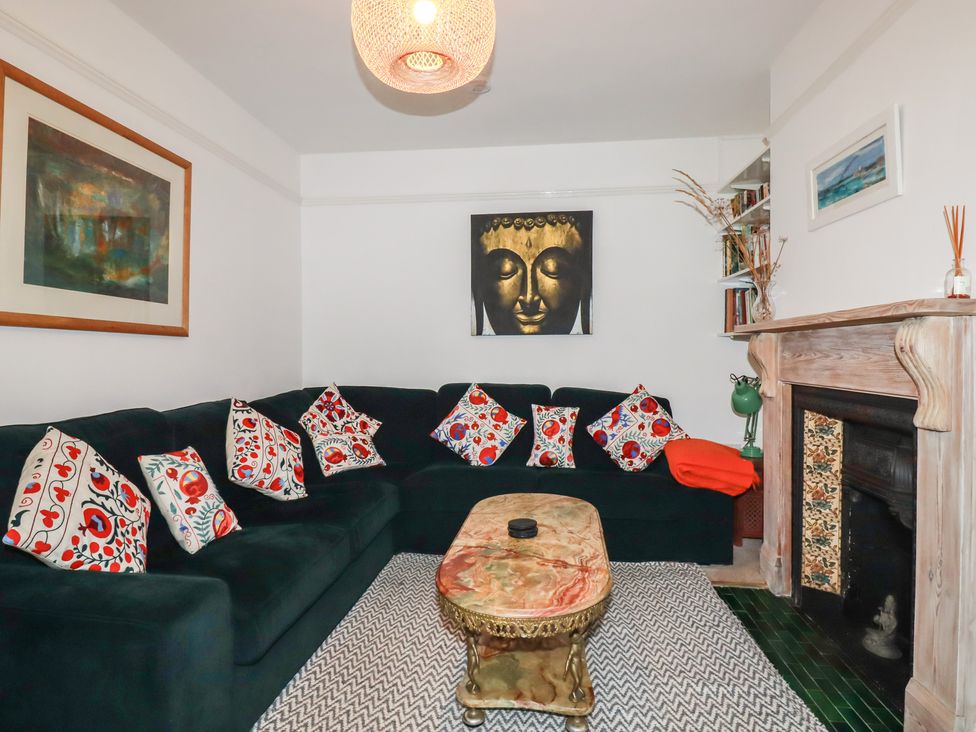 A living room with a green sofa and a coffee table at Lost In The Woods Lodge near Bodmin