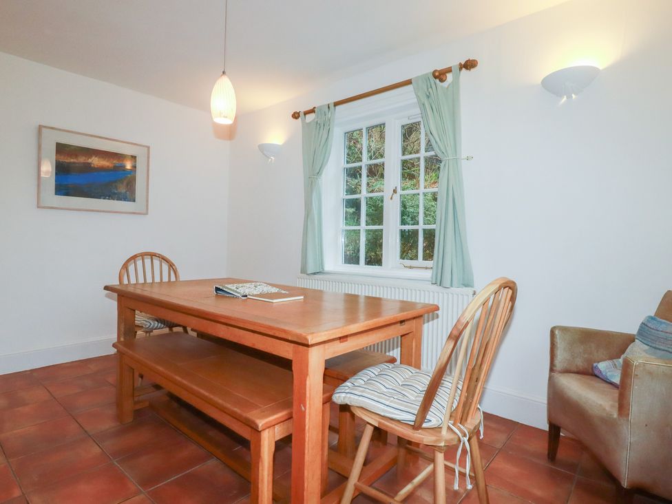 A dining room with a table and chairs at Lost In The Woods Lodge near Bodmin