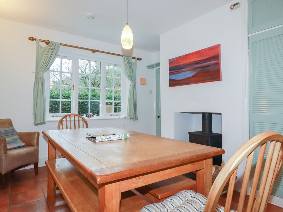 A dining room with a wooden table and chairs at Lost In The Woods Lodge near Bodmin