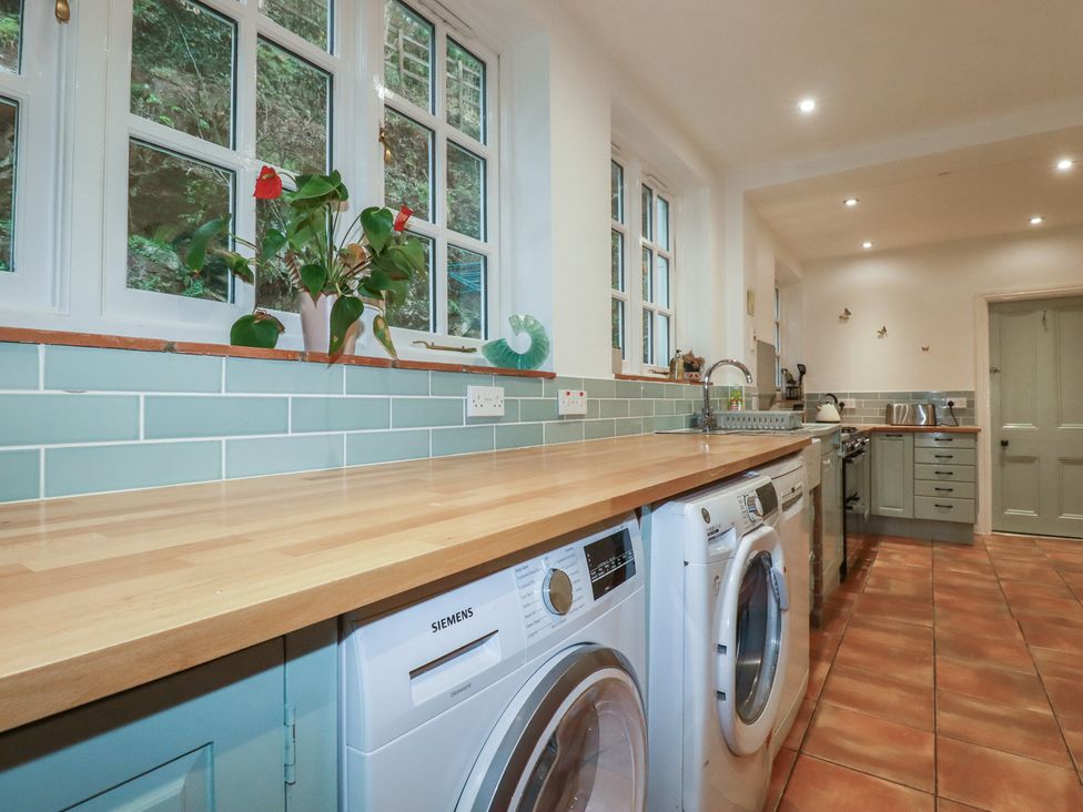A laundry room with washing machine and dryer at Lost In The Woods Lodge near Bodmin