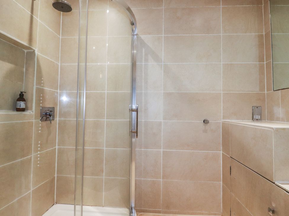 A bathroom with a shower and sink at Lost In The Woods Lodge near Bodmin