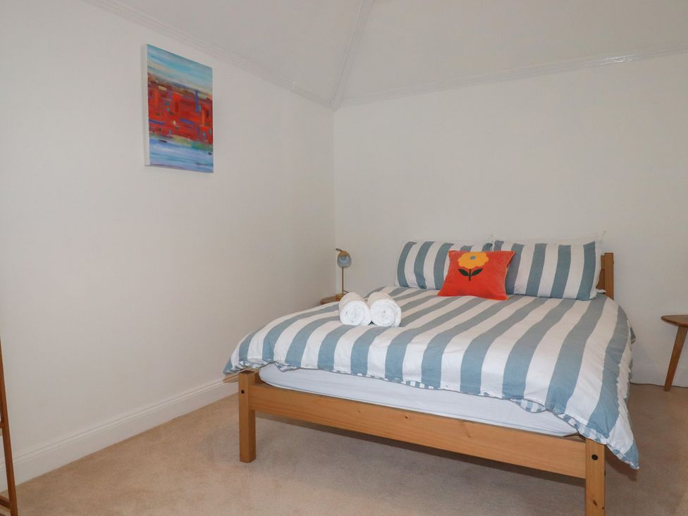 A bedroom with a bed and bedside table at Lost In The Woods Lodge near Bodmin