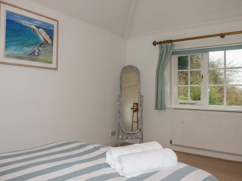 A bedroom with a bed and towels on it at Lost In The Woods Lodge near Bodmin