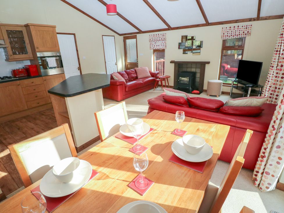 A living room with a dining table and sofa at Riverside Lodge 3