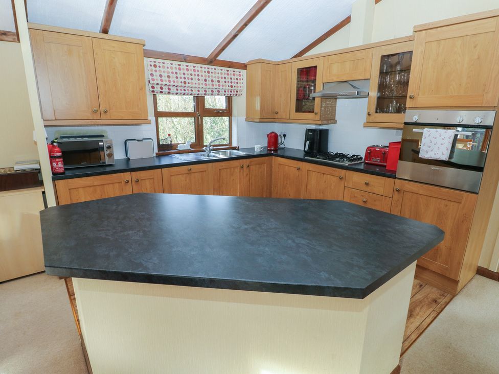 A kitchen with cabinets and appliances at Riverside Lodge 3