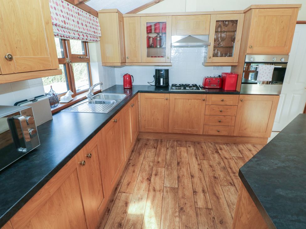 A kitchen with cabinets and appliances at Riverside Lodge 3