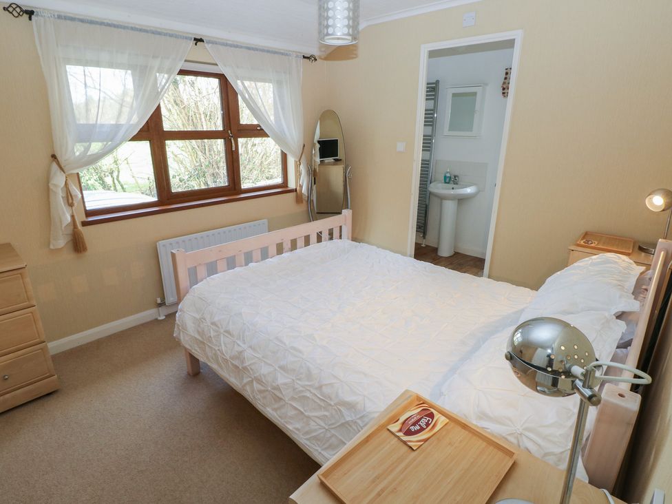 A bedroom with a bed and a window at Riverside Lodge 3