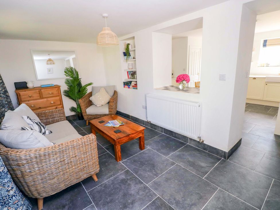A living room with a sofa and coffee table at Coach House Cottage
