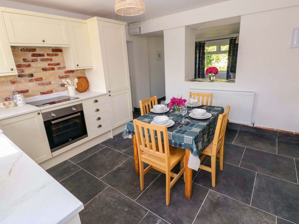 A dining room with a table set for dinner at Coach House Cottage